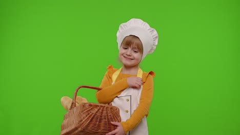 Child-girl-chef-cook-showing-basket-with-baguette-and-bread,-smiling,-sniffing-on-chroma-key