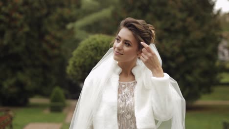 Hermosa-Y-Encantadora-Novia-Con-Vestido-De-Novia-Y-Velo-En-El-Parque-Esperando-Al-Novio.-Camara-Lenta