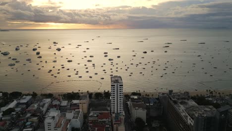 Aerial-at-sunset-of-Pattaya-Thailand-with-beach-road-and-walking-street-boat-moored-at-bay