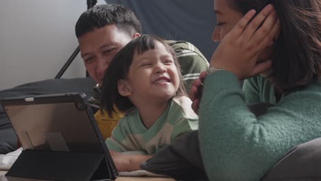 Little-Girl-And-Her-Parents-Enjoying-Watching-Funny-Online-Video-At-Home,-Happy-Asian-Family-Spending-Time-Together