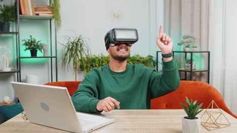 Indian-man-using-virtual-reality-futuristic-technology-headset-play-simulation-3D-video-game-at-home