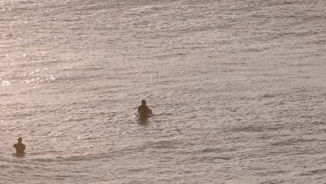 Close-shot-of-surfers-waiting-for-waves-at-sunrise,-Bondi-Beach