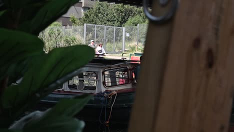 Pulling-a-canoe-boat-past-No90-Hackney-Wick,-London,-United-Kingdom