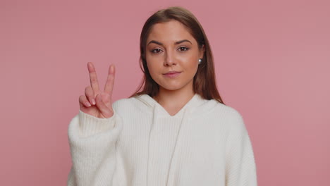 Hipster-optimistic-young-woman-showing-victory-sign,-hoping-for-success-and-win,-doing-peace-gesture