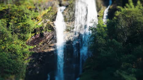 Tilt-Shift-Video-Eines-Malerischen-Wasserfalls,-Der-Durch-Den-üppigen,-Grünen-Wald-Des-Naeroy-Fjords-Stürzt