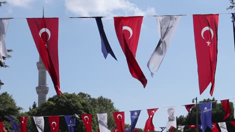 Colorful-flags,-including-the-national-flag-and-other-cultural-event-banners,-hang-against-the-sky-in-Istanbul,-Turkey