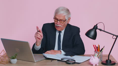 Thoughtful-senior-businessman-making-notes,-writing-down-thoughts-with-pen-into-notepad-notebook