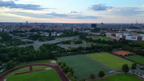 Campos-De-Fútbol-Rodeados-De-Paisaje-Urbano-Con-El-Sol-Poniente-Arrojando-Un-Cálido-Resplandor