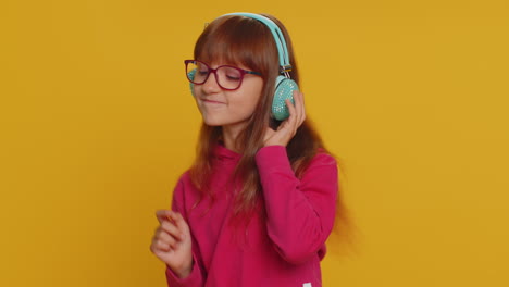 Happy-preteen-child-girl-kid-listening-music-via-headphones-and-dancing-disco-fooling-around