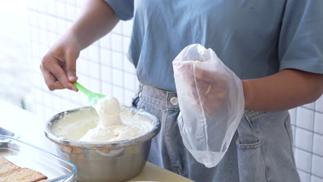 Junge-Frau-Mit-Silikonspatel,-Die-Sahne-In-Plastik-Einfüllt,-Für-Die-Cremezutaten-Für-Tiramisu-Kuchen