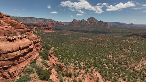 Mountainscape-Reveal-Of-Red-Rocks-And-Green-Forest-In-Sedona,-Arizona,-Aerial-View