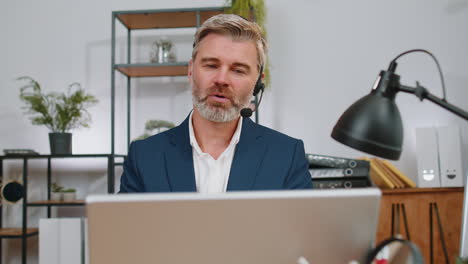 Businessman-working-on-laptop-wearing-headset,-call-center-support-service-operator-office-helpline