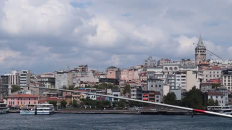 View-of-the-Galata-Tower-in-Istanbul,-Turkey,-surrounded-by-a-residential-area-with-a-bay-area-in-front