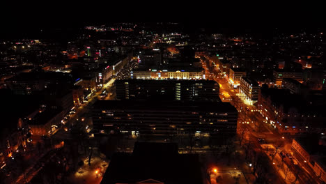 Drone-flying-around-the-illuminated-downtown-of-Vaasa,-nighttime-in-Finland