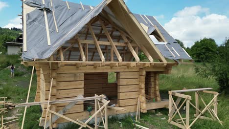 Holzhaus-Im-Bau,-Aus-Baumstämmen-Gefertigt-Und-In-Einer-Wunderschönen-Landschaft-An-Einem-Schönen-Sommertag-Gelegen