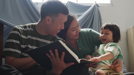 Familia-Asiática-Leyendo-Un-Libro-Y-Pasando-Tiempo-Libre-Juntos-En-Casa