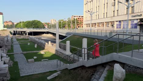 Frau-Im-Orangefarbenen-Kleid-Geht-Die-Treppe-Zum-Forum-Romanum-Von-Philippopolis-Hinunter