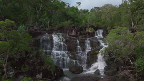 Cascada-De-Upper-Cedar-Creek-Falls-Proserpine-Temporada-De-Lluvias-Qld-Australia-Vista-Aérea-Con-Dron-Islas-Whitsundays-Puerto-De-Airlie-Beach-Nubes-Sombra-Mañana-Durante-El-Día-Reserva-Forestal-Conway-Palmeral-Estático