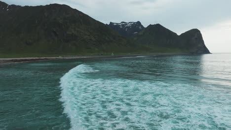 Luftaufnahme-über-Dem-Meer-Mit-Blick-Auf-Den-Strand-Von-Unstad-Und-Die-Surfer,-Die-Auf-Die-Wellen-Warten