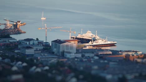 Morning-in-the-port-of-Molde---Ferries-docked-the-terminal,-sail-boat-leaving-the-harbour