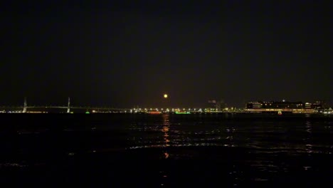 City-skyline-at-night-with-lights-reflecting-on-the-water