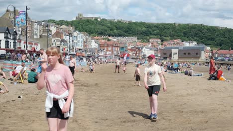 footage-of-Scarborough-beach-full-of-tourists-in-the-sun,-North-Yorkshire-on-a-summer-day-on-a-busy-weekend-with-families-enjoying-the-English-coastal-seaside-resort