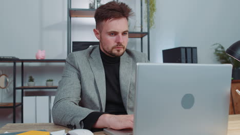 Business-smiling-man-closing-laptop-computer-after-finishing-online-work-remote-job-from-home-office