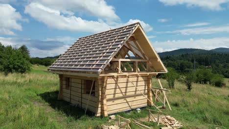 Casa-De-Madera-En-Construcción,-Hecha-De-Troncos-Y-Ubicada-En-Un-Hermoso-Paisaje-En-El-Campo-De-Montaña.