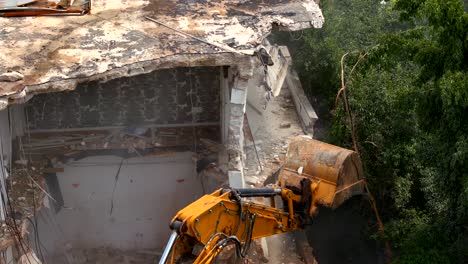 Excavator-demolishing-a-residential-building,-Aerial-view