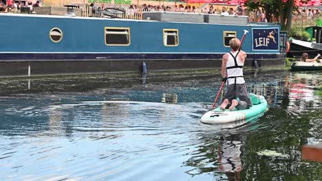 Rowing-on-his-knees-on-River-Lee-past-No90-Hackney-Wick,-London,-United-Kingdom