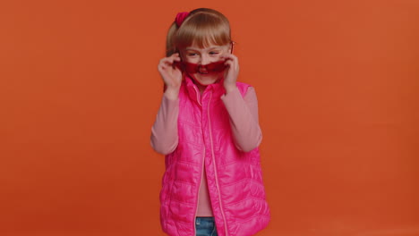 Seductive-cheerful-stylish-girl-in-blouse-and-vest-wearing-sunglasses,-charming-smile-on-pink-wall