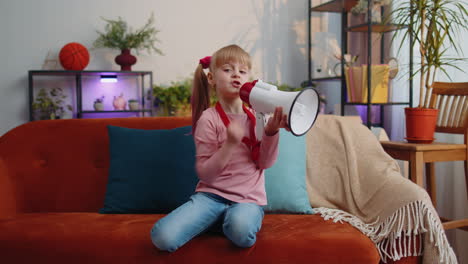 Child-girl-kid-standing-on-sofa-at-home-alone-loudly-shout-in-megaphone-announces-discounts-sale