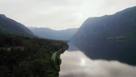 Drone-shot-over-Lake-Bohinj-in-Slovenia-with-mountains-in-the-backdrop-as-the-sun-sets