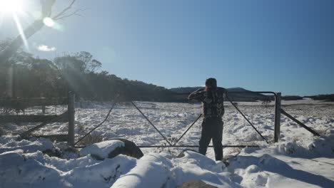 A-bushman-looking-out-at-stockyards-on-a-snowy-plain-in-the-Victorian-high-country