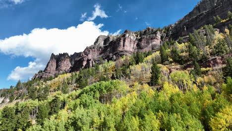 Vista-Aérea-De-Una-Montaña-De-Color-Amarillo-Y-Verde-Vibrante-Con-Cielo-Azul-En-Telluride,-Colorado