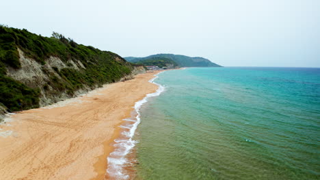 Aerial-drone-shot-over-the-long-stretching-empty-sandy-beach-in-Corfu-in-Greece