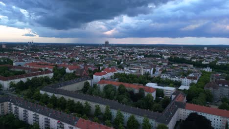 Modernes-Europäisches-Stadtbild-Mit-Wohngebäuden,-Einer-Autobahn-Und-üppigen-Grünflächen-Unter-Einem-Bewölkten-Himmel-Bei-Sonnenuntergang