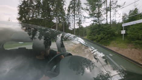 Joven-Saliendo-Con-El-Coche-Por-Una-Carretera-De-Montaña