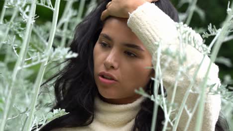 Woman-with-dark-hair-and-deep-eyes-posing-in-jungle-forest,-close-up