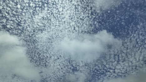 Timelapse-of-a-sky-speckled-with-small-white-clouds-with-a-changing-light