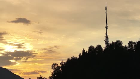 Silhouette-Eines-Hohen-Kommunikationsturms-Auf-Einem-Hügel-Bei-Sonnenuntergang-In-Glarus-Nord,-Schweiz