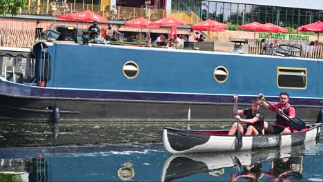 Two-men-rowing-on-River-Lee,-No90-Hackney-Wick,-London,-United-Kingdom