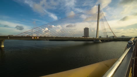 Da-Nang-bridge,-traffic-flow,-dynamic-motion-with-cloud-formations