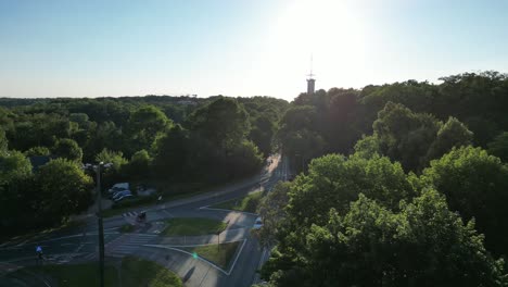 Outskirt-intersection-surrounded-by-lush-greenery,-grass-and-trees-under-a-clear-blue-sky-durring-sunset