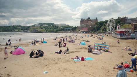 footage-of-Scarborough-beach-full-of-tourists-in-the-sun,-North-Yorkshire-on-a-summer-day-on-a-busy-weekend-with-families-enjoying-the-English-coastal-seaside-resort