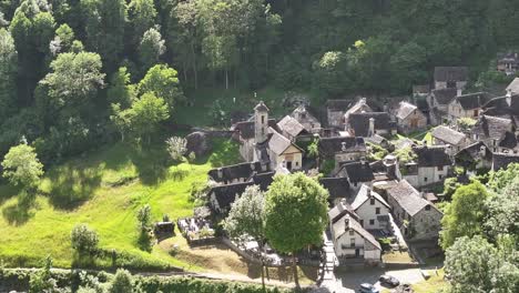 Vista-Aérea-De-Un-Pintoresco-Pueblo-Rodeado-De-Exuberante-Vegetación-En-El-Valle-De-Maggiatal,-Ticino,-Suiza