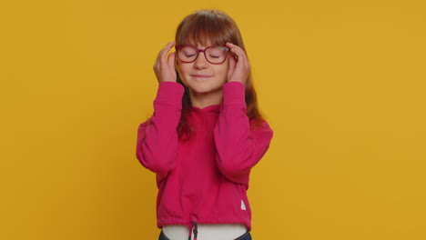 Cheerful-lovely-young-preteen-child-girl-kid-smiling,-looking-at-camera-on-studio-yellow-background