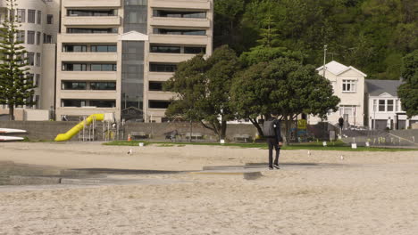 Un-Fotógrafo-Malasio-Camina-Y-Luego-Toma-Una-Fotografía-En-Oriental-Bay-Parade,-Wellington,-Nueva-Zelanda-(toma-Panorámica)