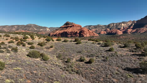 Backwards-Tracking-Of-Red-Rock-Mountains-and-Green-Desert-Foilage-In-Sedona,-Arizona,-Aerial-View