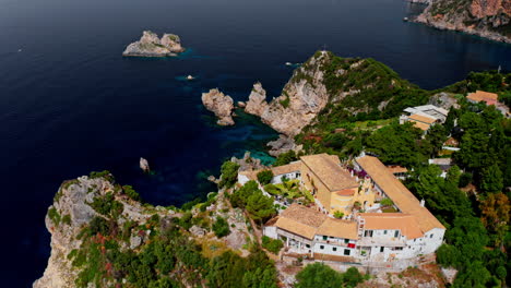 Aerial-drone-shot-over-the-monastery-of-Paleokastritsa-sitting-on-top-of-a-rocky-cliff-in-Corfu,-Greece